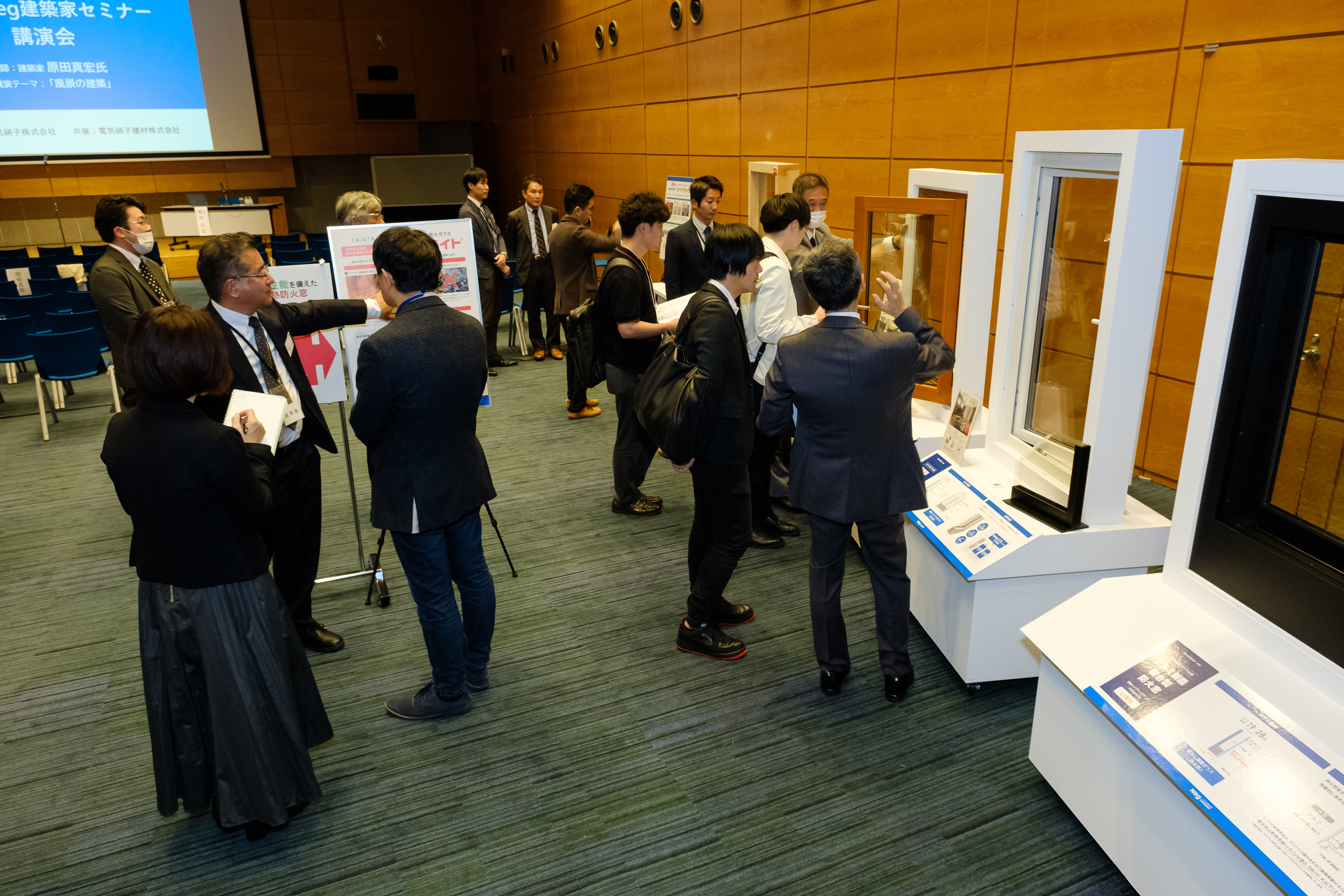 会場内の展示コーナーにてNEGのガラス建材製品に触れる来場者